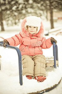 下雪玩耍摄影照片_冬天公园里的雪地上玩耍的漂亮宝宝。全长肖像，复古色调