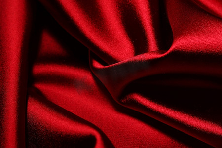 红色褶皱摄影照片_红色绸缎背景特写