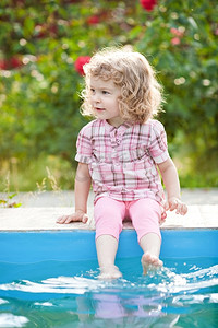 坐在夏园游泳池边微笑的孩子