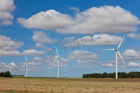 田野里的一排四台绿色能源风电机组