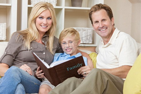 儿童相册相册摄影照片_幸福的一家人坐在沙发上看相册