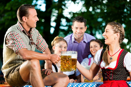 巴伐利亚州摄影照片_啤酒花园--德国巴伐利亚州莱德霍森的朋友们喝着新鲜啤酒
