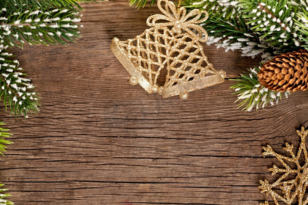树枝元素摄影照片_木质背景上的树枝和铃铛构成的圣诞边框