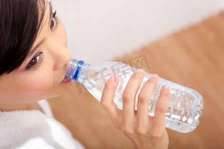 亚裔中国女孩喝着一瓶纯净水