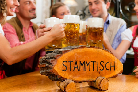 开州摄影照片_巴伐利亚州的客栈或酒吧--五名年轻男女在传统的Tracht喝着啤酒，开着啤酒聚会