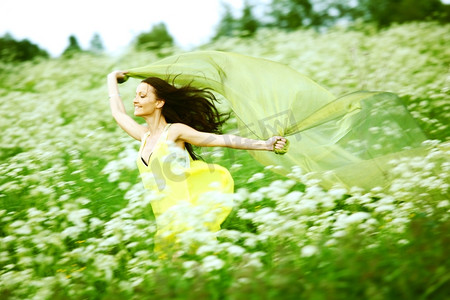 姑娘跑过田野,手握织物,像翅膀一样在身后飞翔天空草原姑娘跑过田野