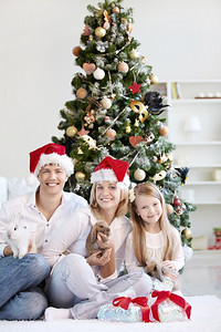 兔年贺词摄影照片_家庭圣诞节戴着帽子，兔子在家里