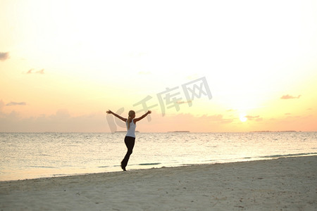 一名女子沿着日出后的海边奔跑