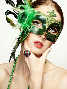 美丽的年轻女子在一个绿色的神秘威尼斯面具