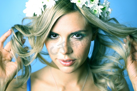 个性花朵摄影照片_头发上戴着蓝色花朵的年轻女子