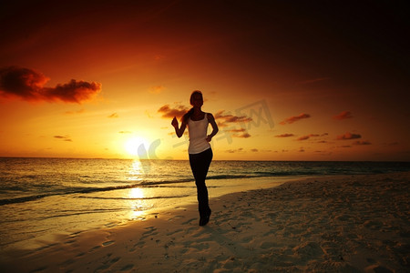 一名女子沿着日出后的海边奔跑