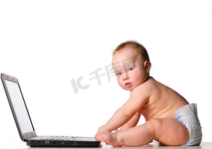 小婴儿在笔记本电脑上工作，隔离在白色背景上