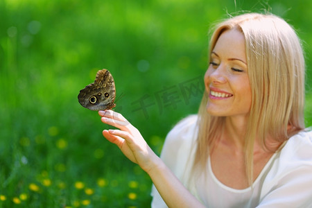 免费美容摄影照片_妇女玩一只蝴蝶在绿草