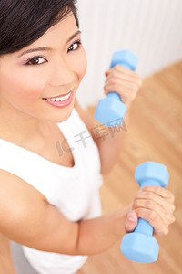 美丽的年轻亚洲中国女人举重在健身房
