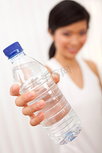 亚裔中国女孩拿着瓶装纯净水对着镜头