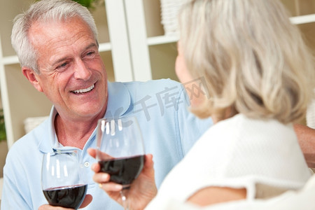 快乐的高级男人&女人夫妇喝葡萄酒在家里