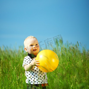 年轻的微笑男孩打黄球