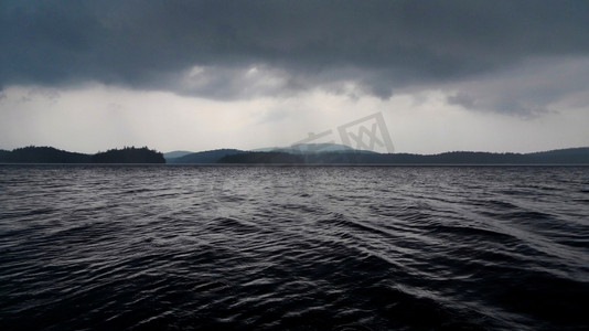 暴风哭泣摄影照片_令人望而生畏的深沉的暴风雨湖和云。