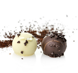 bonbon摄影照片_白色和黑巧克力果仁糖，特写镜头，在白色背景
