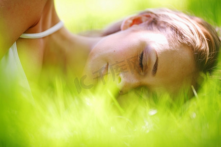 女人睡在绿色的草地上