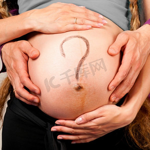 问题。男女手抱着一名孕妇的肚子，背景为灰色，肚子上有说明文字