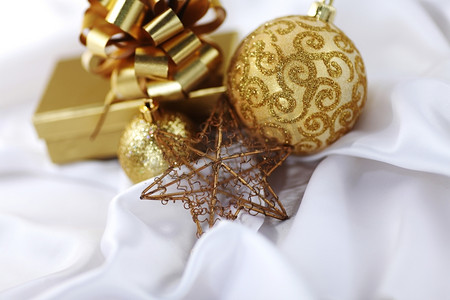 白色丝绸上的金色圣诞球