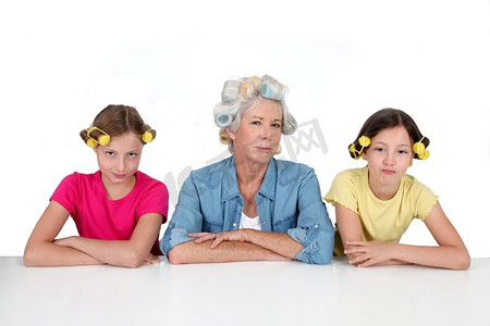 卷发机摄影照片_老年妇女和儿童使用卷发机