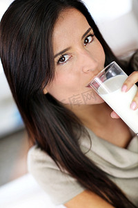 年轻貌美的女人喝着新鲜牛奶