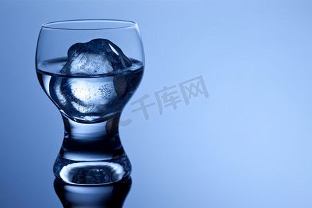 装冰块的杯子摄影照片_这是一款外形精美的酒杯，里面装着水晶伏特加和冰块。
