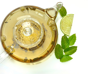 绿色茶壶摄影照片_用茶壶、酸橙和薄荷制成的绿茶