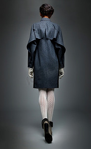 贵族-苗条的黑发时尚模特穿着灰色外套，背面立面画。系列照片