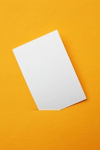 橙色海报背景摄影照片_橙色背景的白纸卡