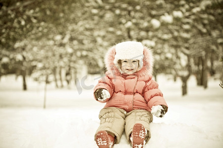儿童玩雪摄影照片_儿童玩雪球在冬季公园