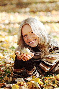 秋天公园里拿着金苹果的女人