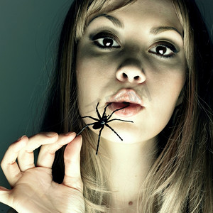 工作室里吃蜘蛛的年轻女人的肖像美女头发