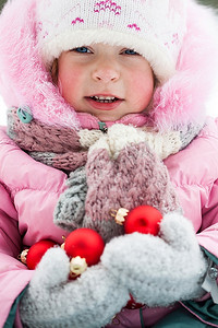 冬日公园里拿着圣诞装饰品的快乐小朋友。户外拍摄