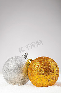 圣诞装饰球摄影照片_雪地上的圣诞装饰球