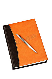 日记本，皮套和金属笔放在桌子上，白色背景隔开