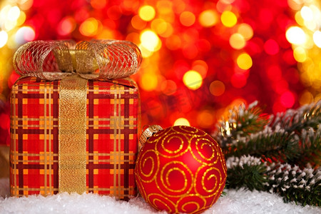 礼品盒和圣诞树装饰品在灯光的背景下下雪