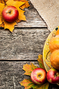 旧木桌上的苹果和枫叶做成的秋框。感恩节的概念