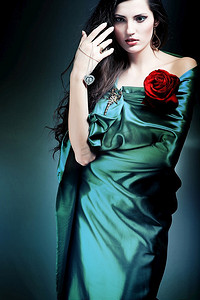 戴花的美女摄影照片_穿着绿色面料，戴着红玫瑰的美女