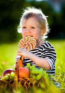 一个小男孩在绿色的草地上吃甜食