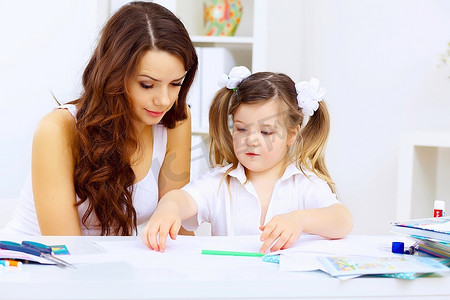 年轻的母亲和她的小女儿在家里一起学习
