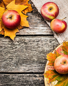 旧木桌上的苹果和树叶做成的秋框。感恩节的概念