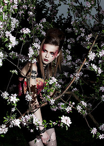 美妆春天摄影照片_鲜花。化着时髦妆容的美女在盛开的苹果树间摆姿势