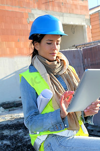 建设经理摄影照片_建筑师在建筑工地上使用电子平板电脑