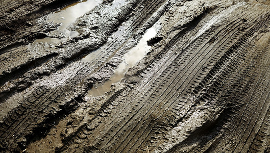 水纹的图案摄影照片_泥浆上的轮胎花纹有反光和水纹，选择性聚焦