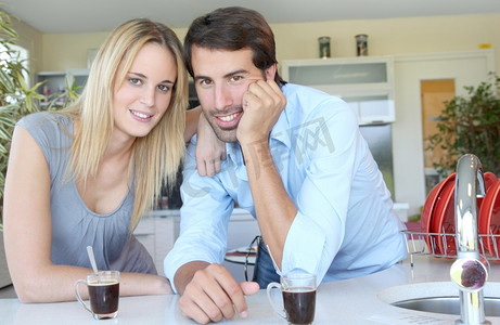 幸福的年轻夫妇站在家里的厨房里