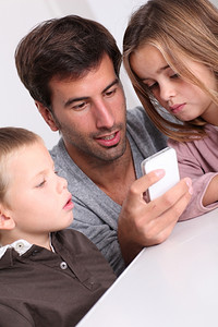 父亲和孩子玩智能手机