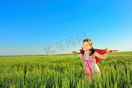 田野上撑着伞的小女孩